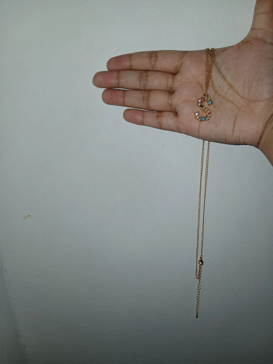 Gold tone necklace with crystal initial 'S'