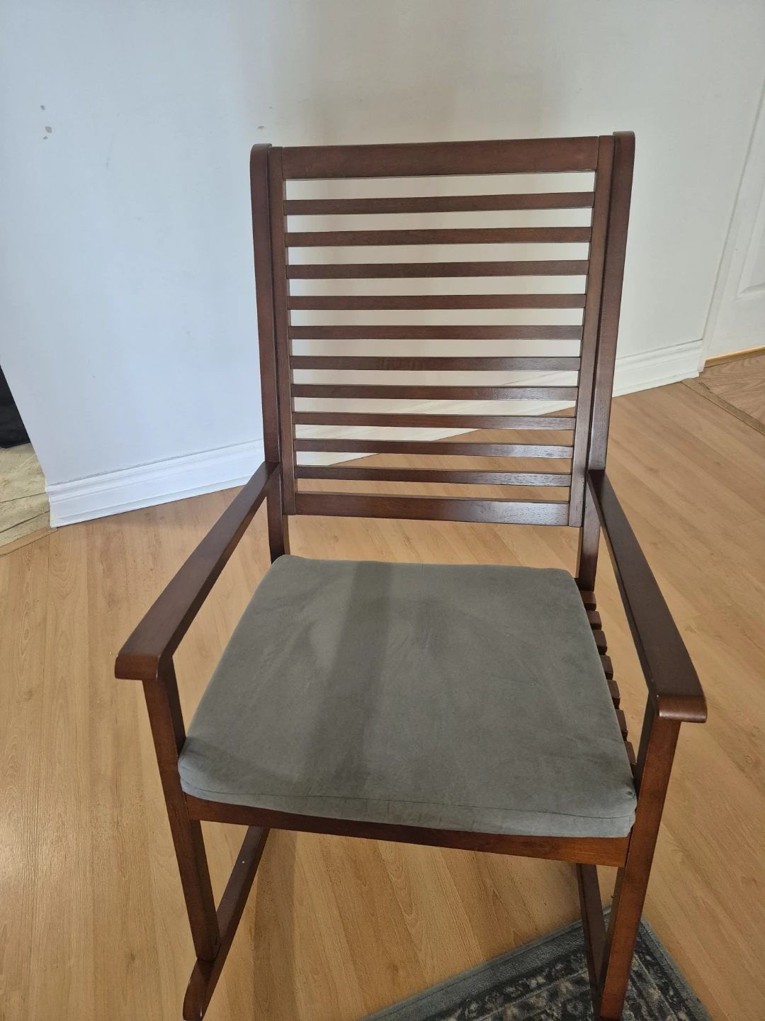Wooden rocking chair with grey cushion