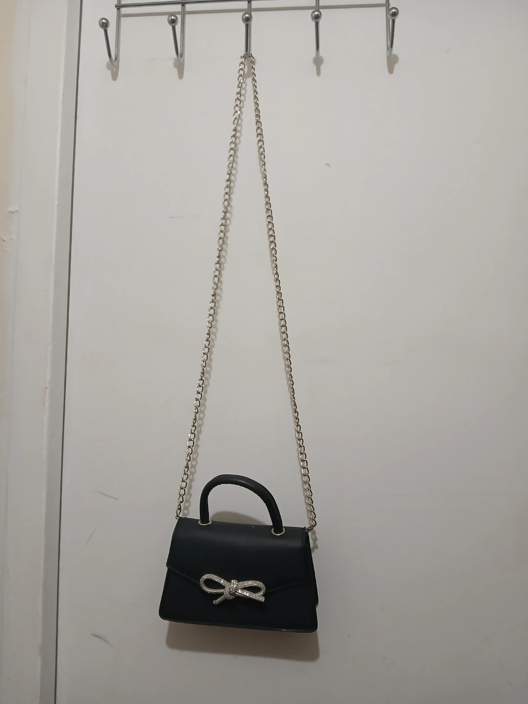 Black handbag with chain strap and bow detail