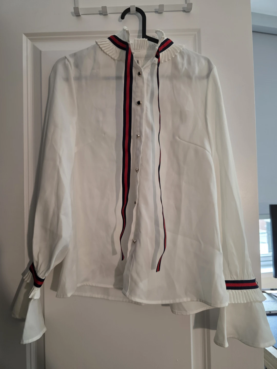 White blouse with red and black ribbon