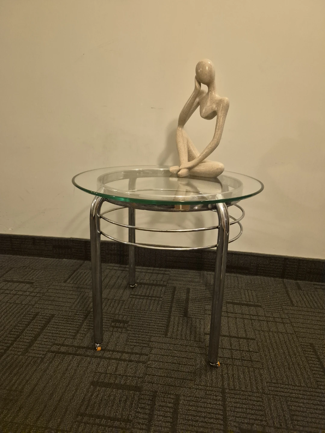 Glass top side table with silver legs and wheels