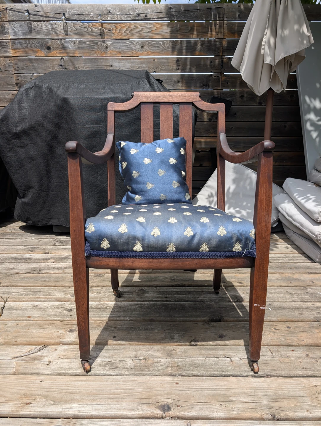 Wooden accent chair with blue bee-patterned seat cushion