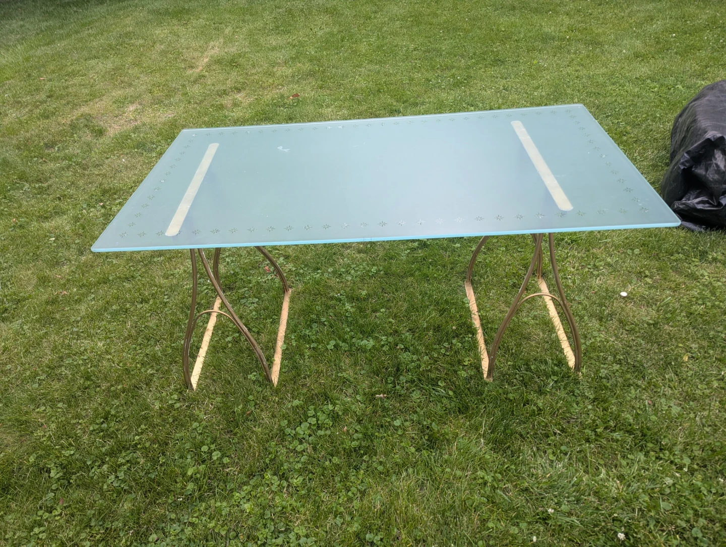 Glass top table with decorative metal frame