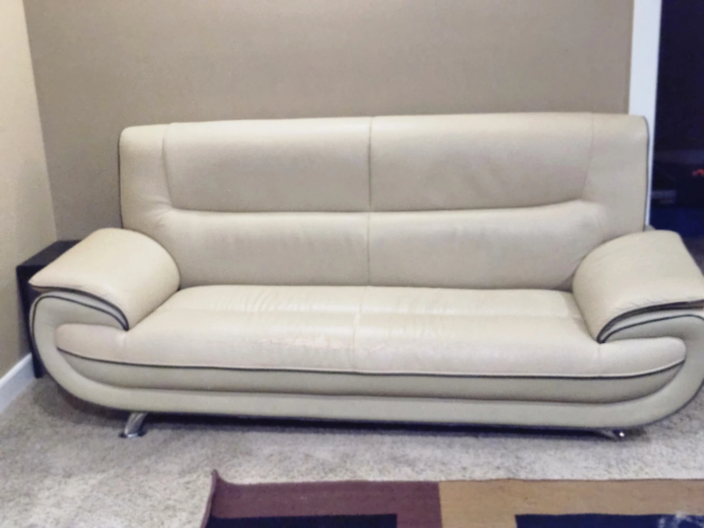 Cream coloured sofa with wear and tear