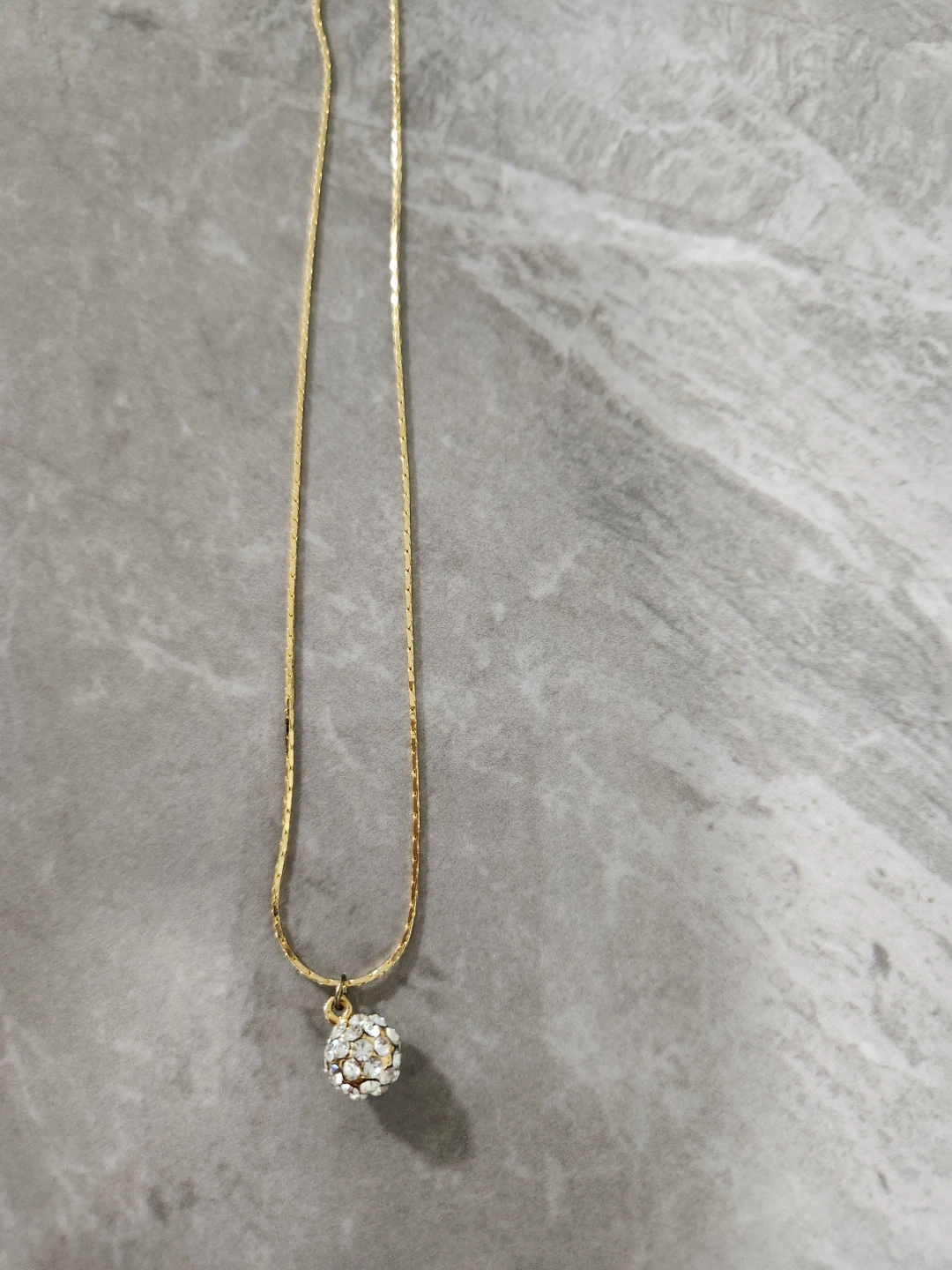 Gold-tone necklace with jeweled ball pendant
