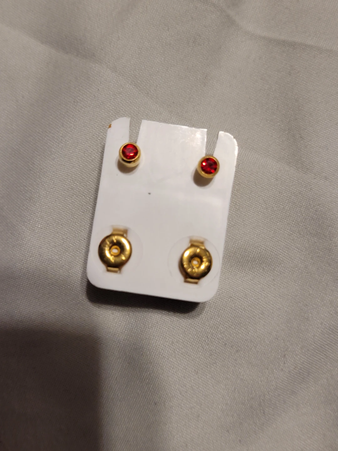 Gold tone stud earrings with red gems