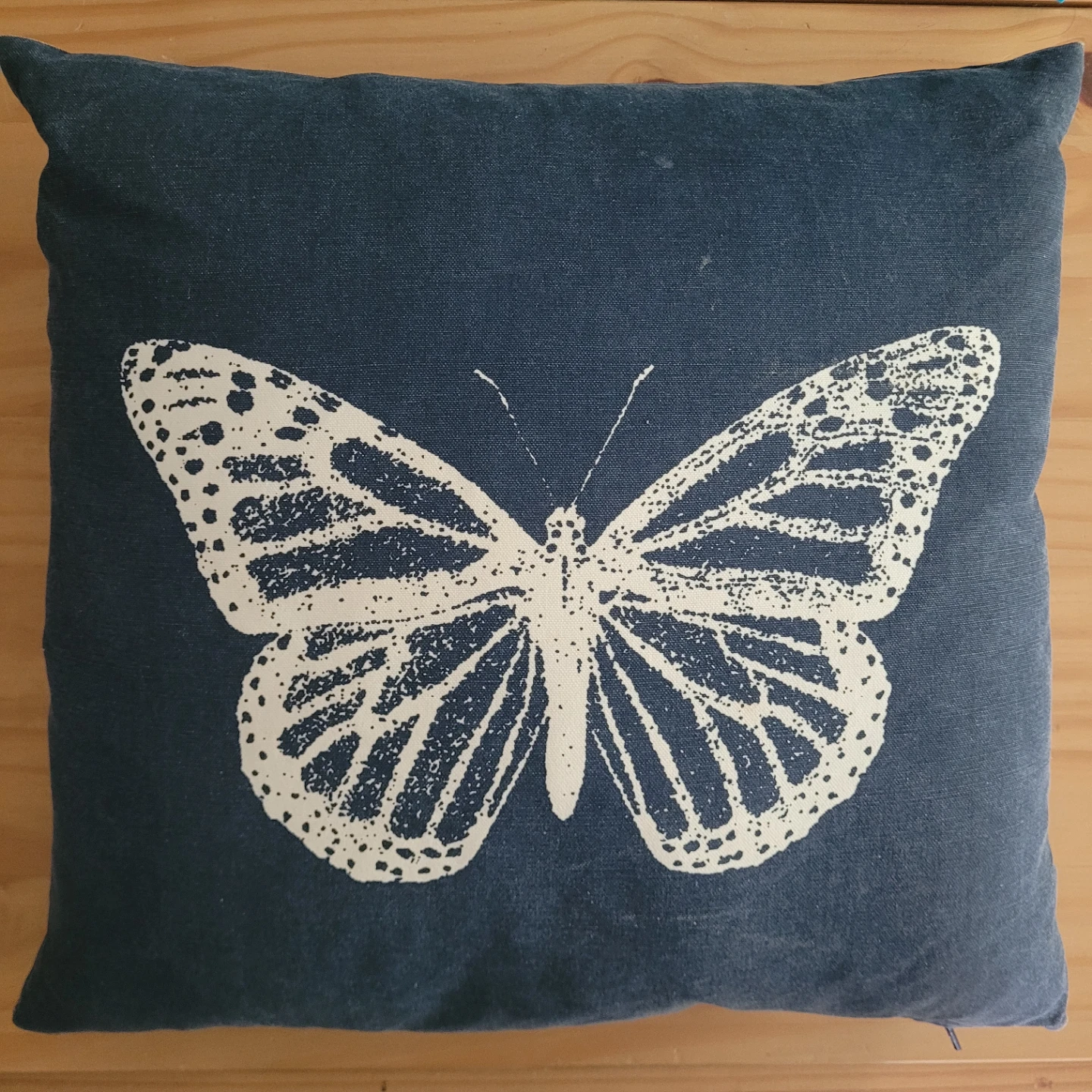 Blue throw pillow with white butterfly design