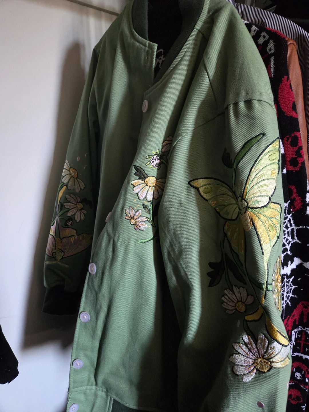 Green bomber jacket with embroidered moths and flowers