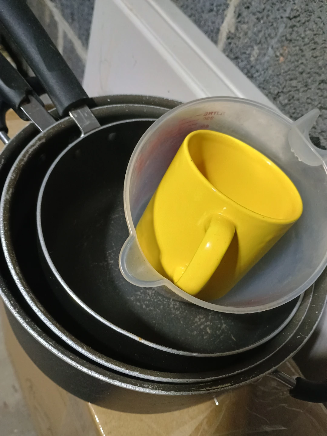 Used Pots, Measuring Cup, and Yellow Mug