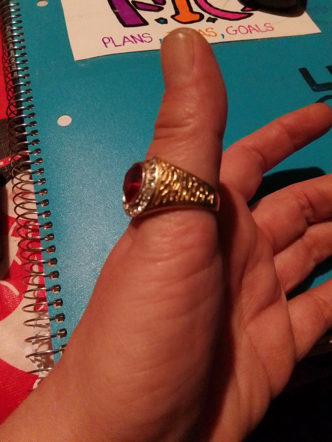 Gold coloured signet ring with red stone