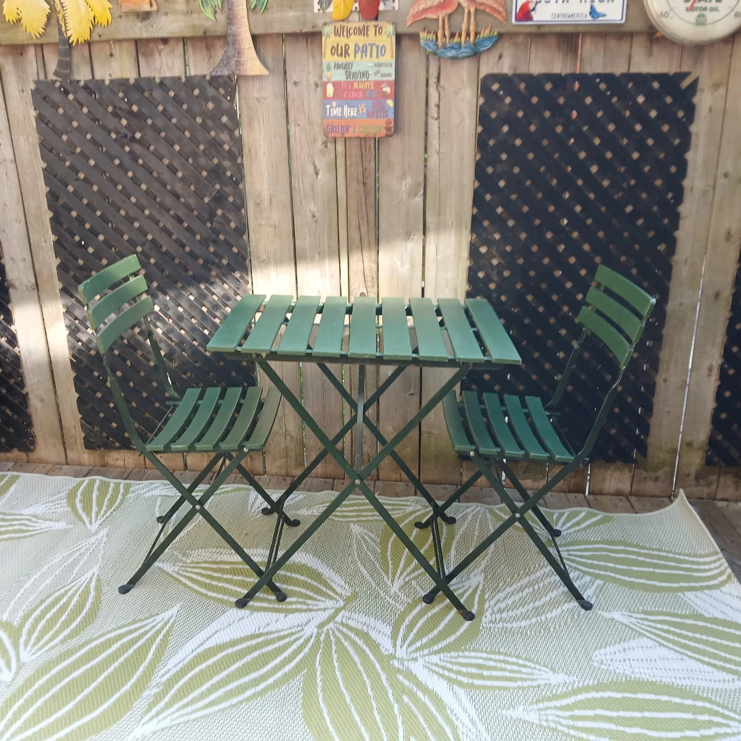 Two green patio seat cushions with floral pattern