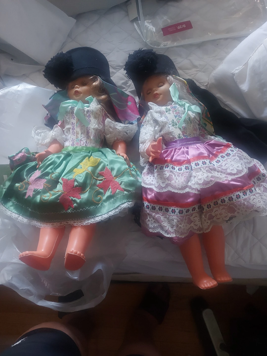 Two vintage dolls with dresses and hats