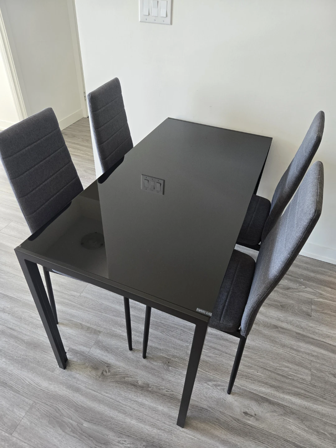 Dining set: black glass table with 4x upholstered gray chairs