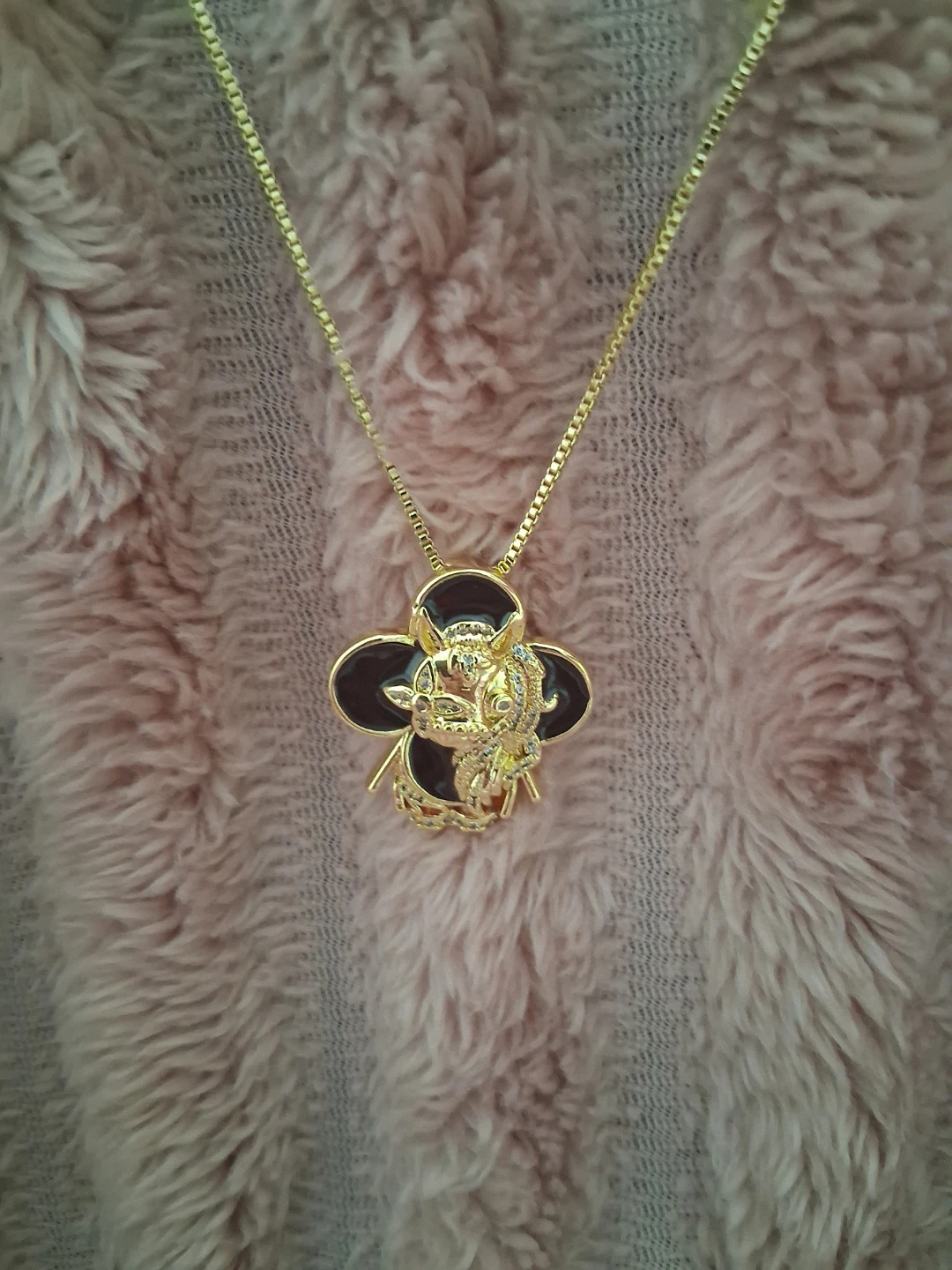Gold tone charm necklace with clover design