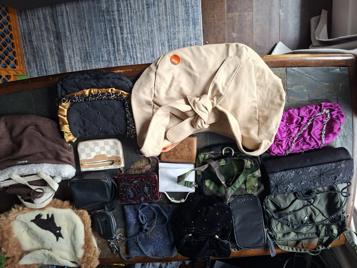 Assorted designer wallets and bags in wicker basket