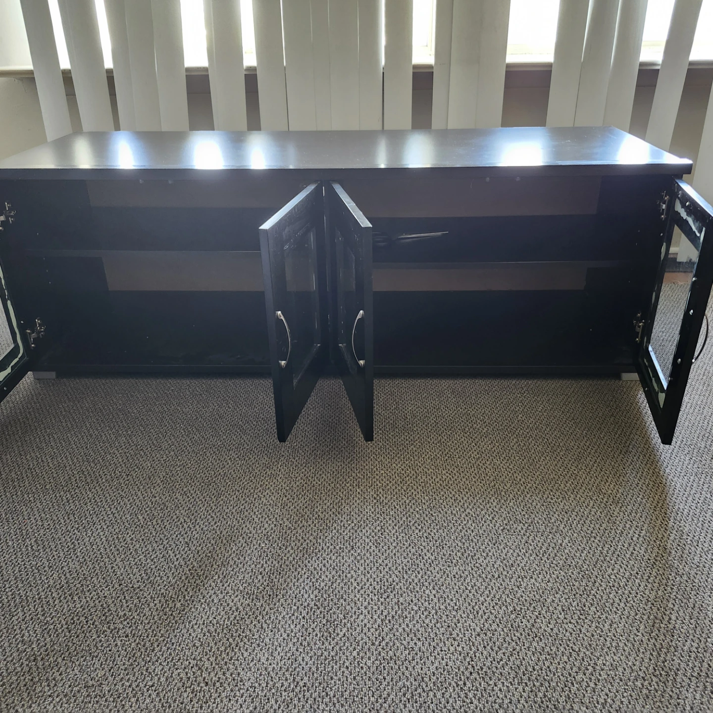 black four-door glass-front TV stand or media console