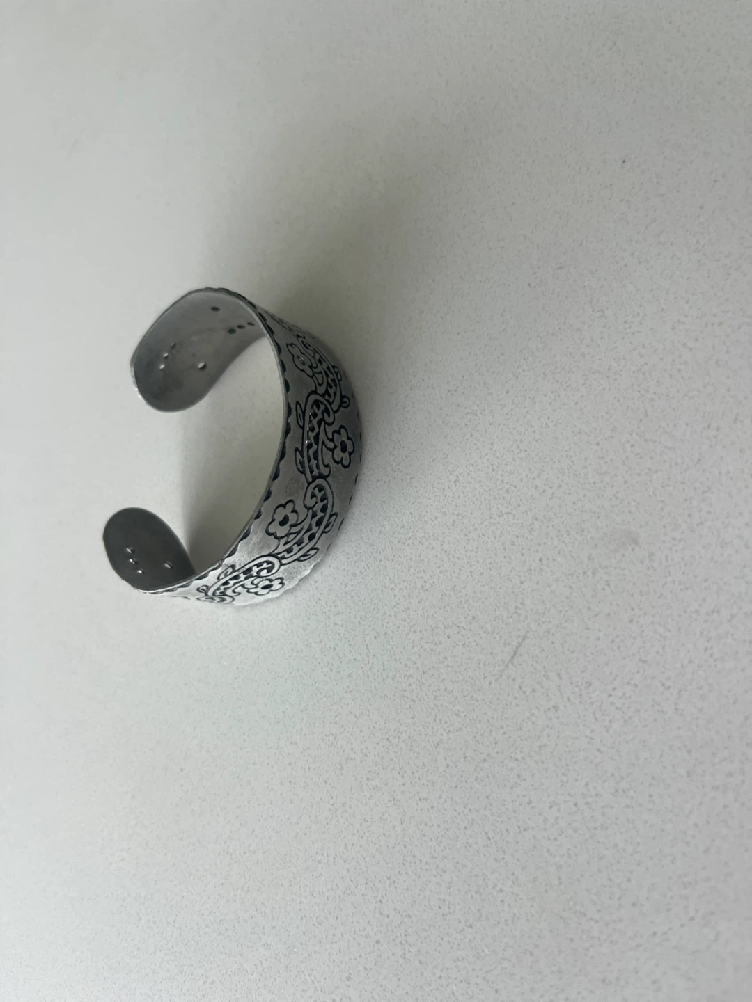 Silver tone cuff bracelet with floral pattern