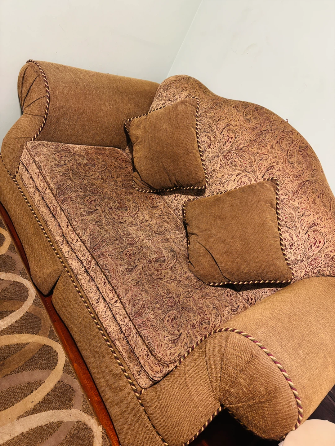 Brown patterned loveseat with throw pillows