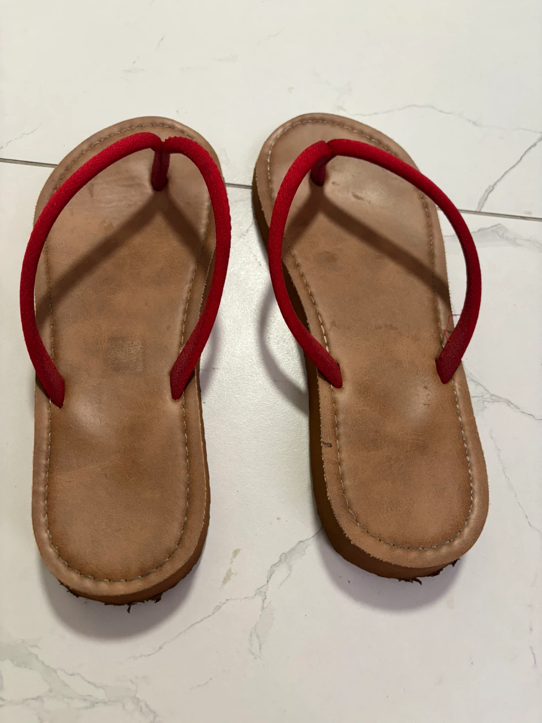 Brown flip-flops with red straps