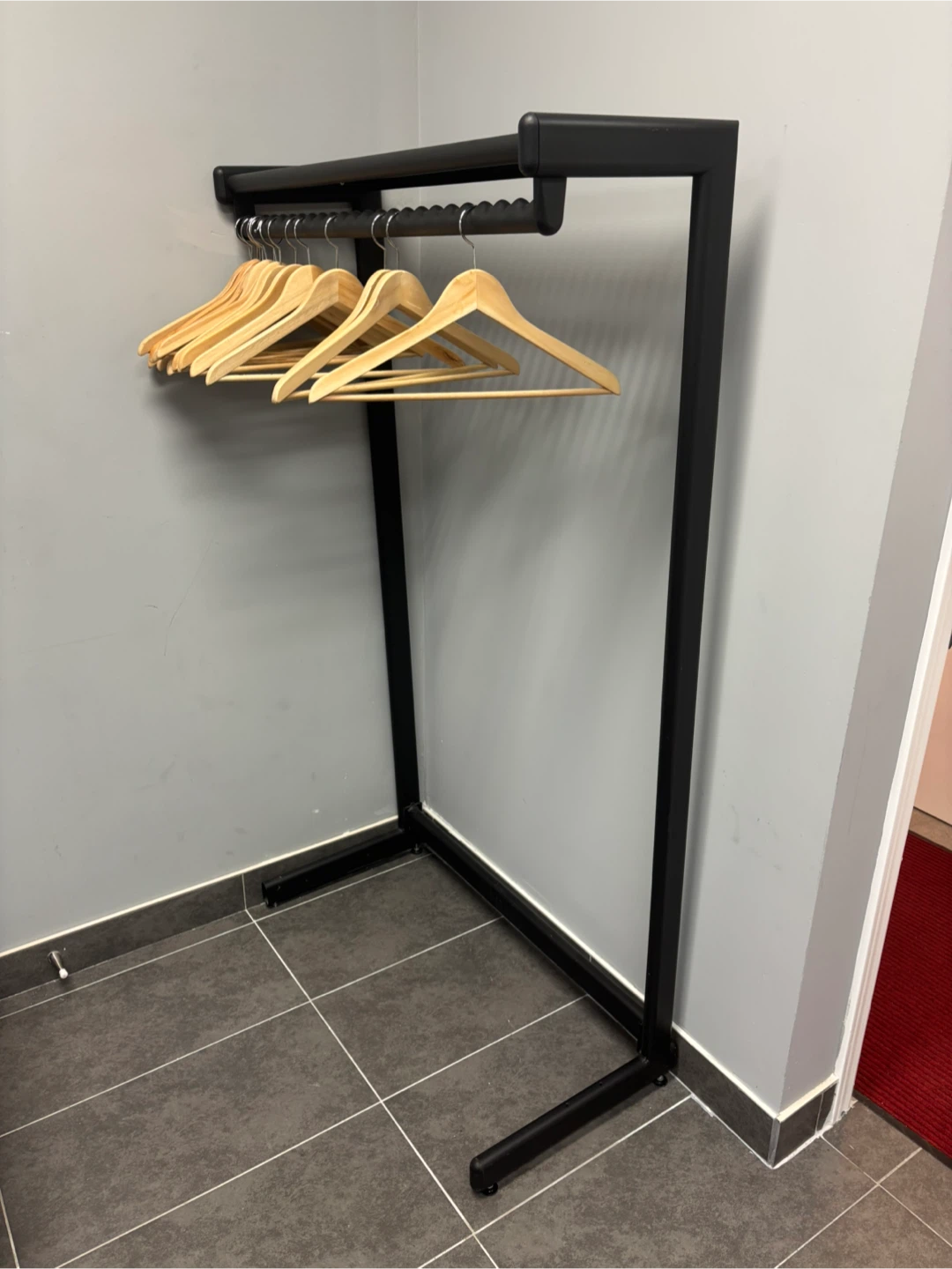 Black metal garment rack with hangers