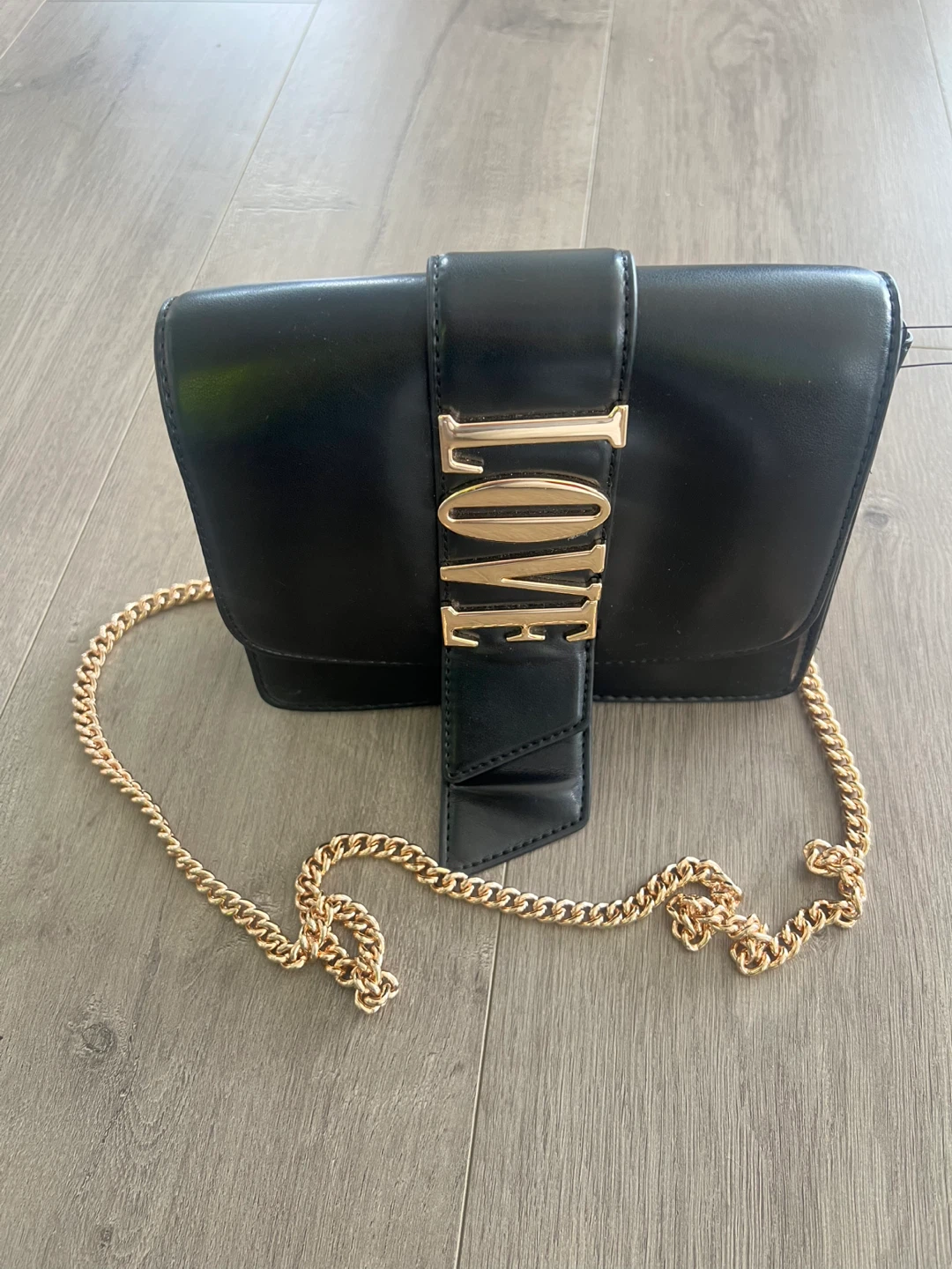 Black crossbody bag with "LOVE" by H&M Europe