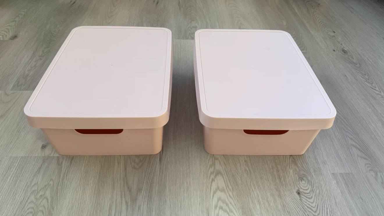 Two like-new soft light pink plastic storage bins