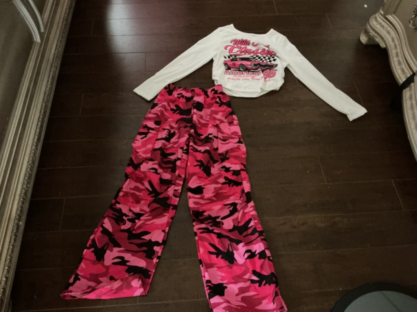 is a pink camouflage by pants. With a white  long-sleeved shirt
