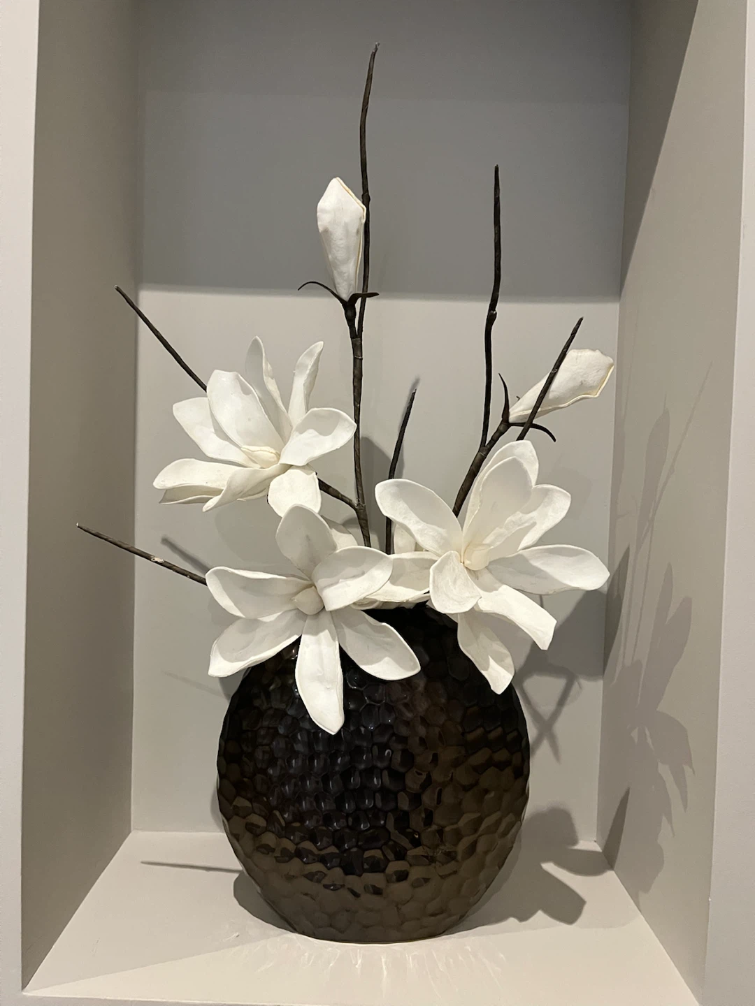 Hammered metal vase with artificial flowers
