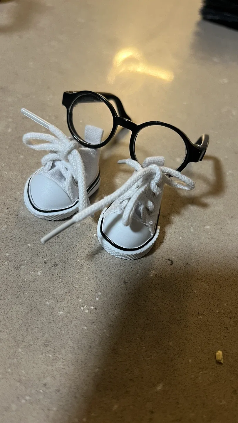 White miniature sneakers and black glasses