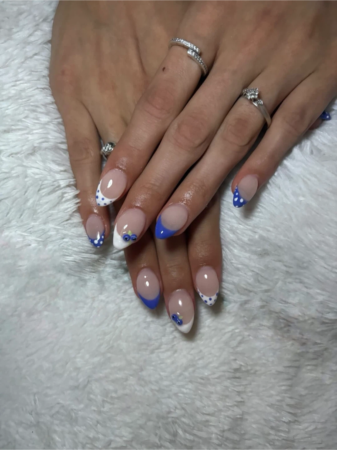 French tip nails with blue polka dots and floral accents