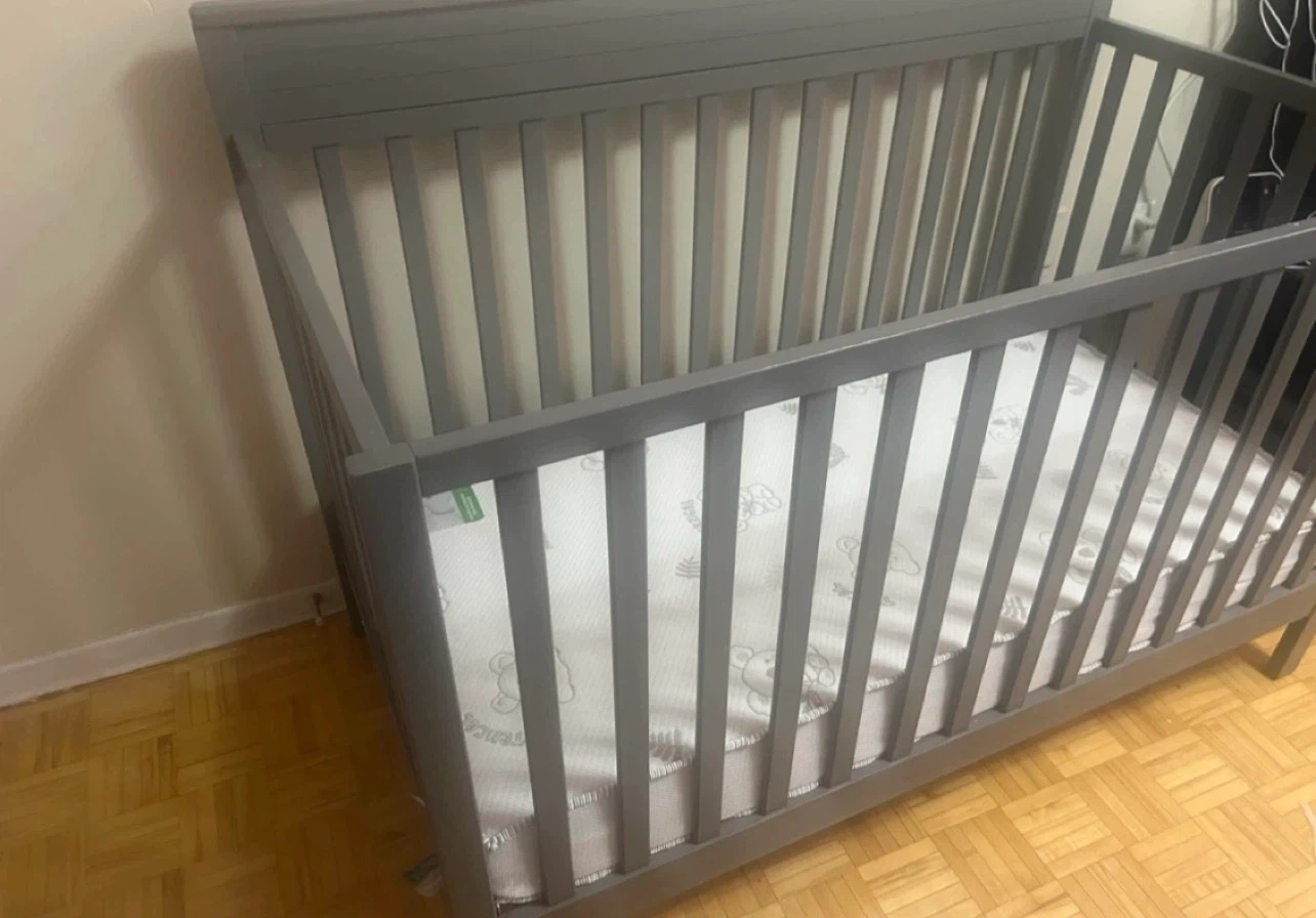 Grey crib with mattress