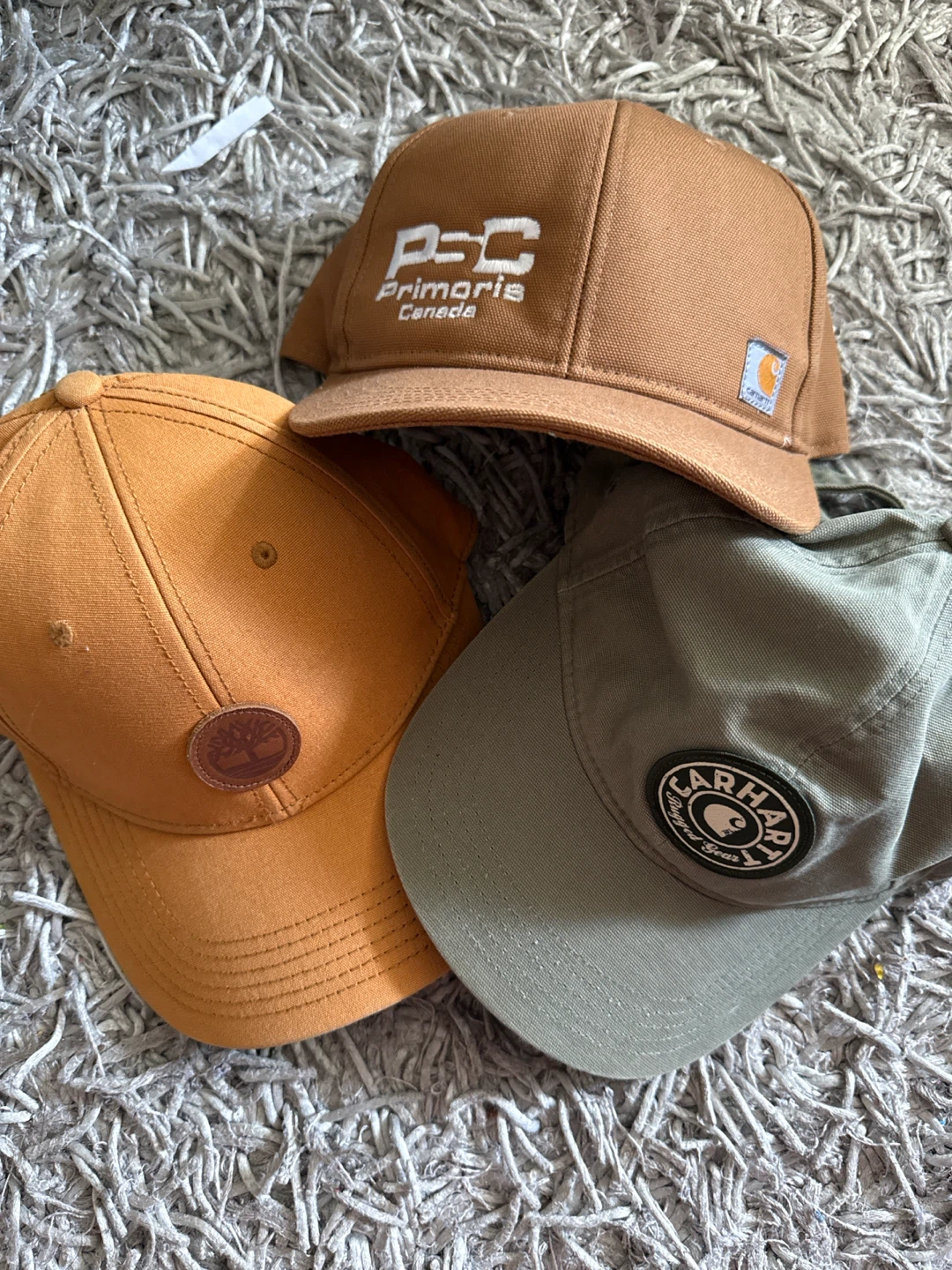Three Baseball Caps: Carhartt, Primoris Canada, Timberland