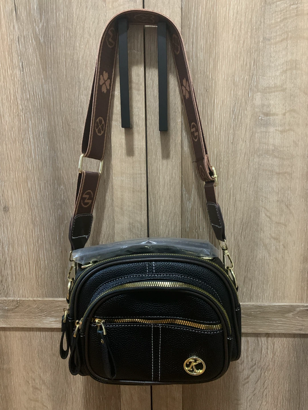 Black crossbody bag with patterned strap