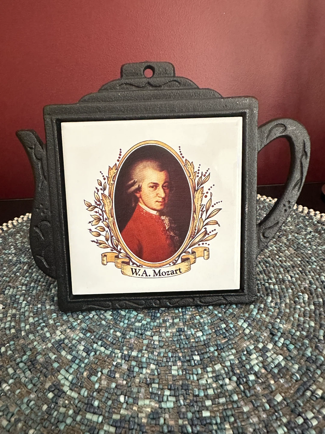 W.A. Mozart ceramic tile trivet in teapot-shaped frame.
