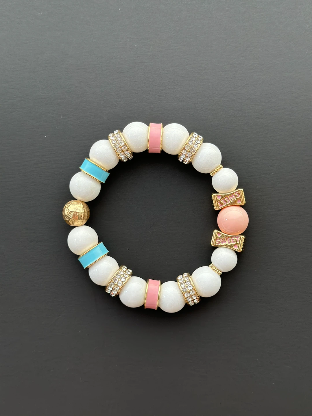 White Beaded Bracelet with Pink, Blue, and Gold Accents