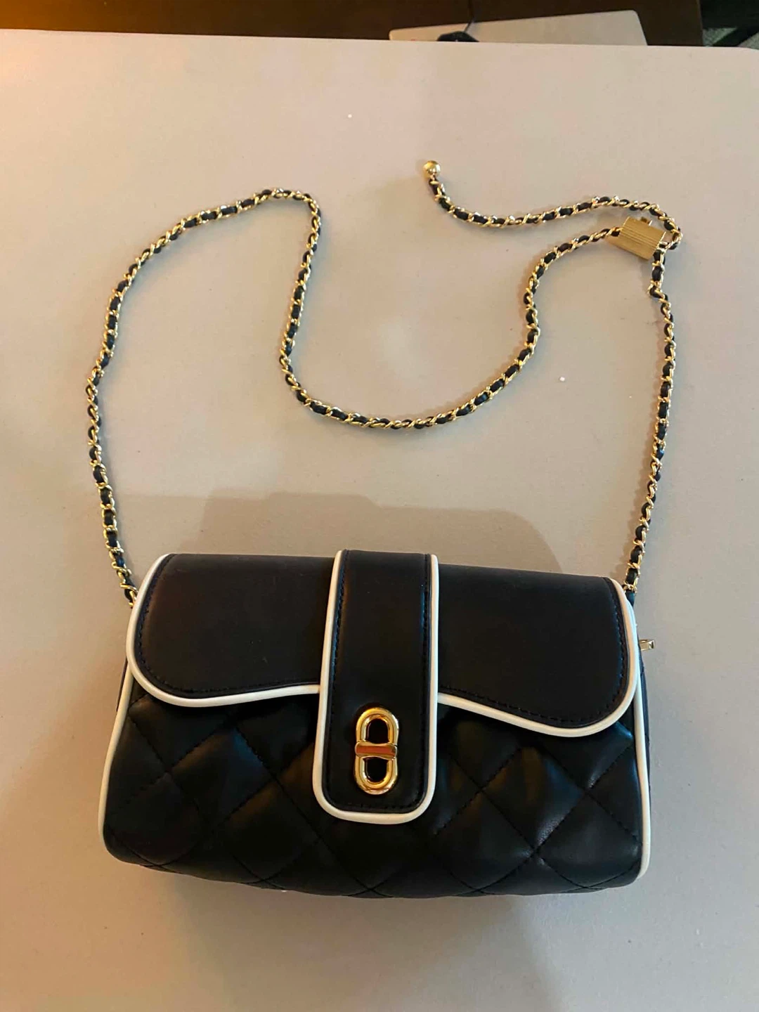 Black quilted crossbody bag with gold chain
