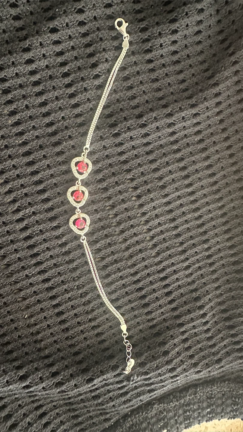 Silver tone chain bracelet with heart charms and red stones