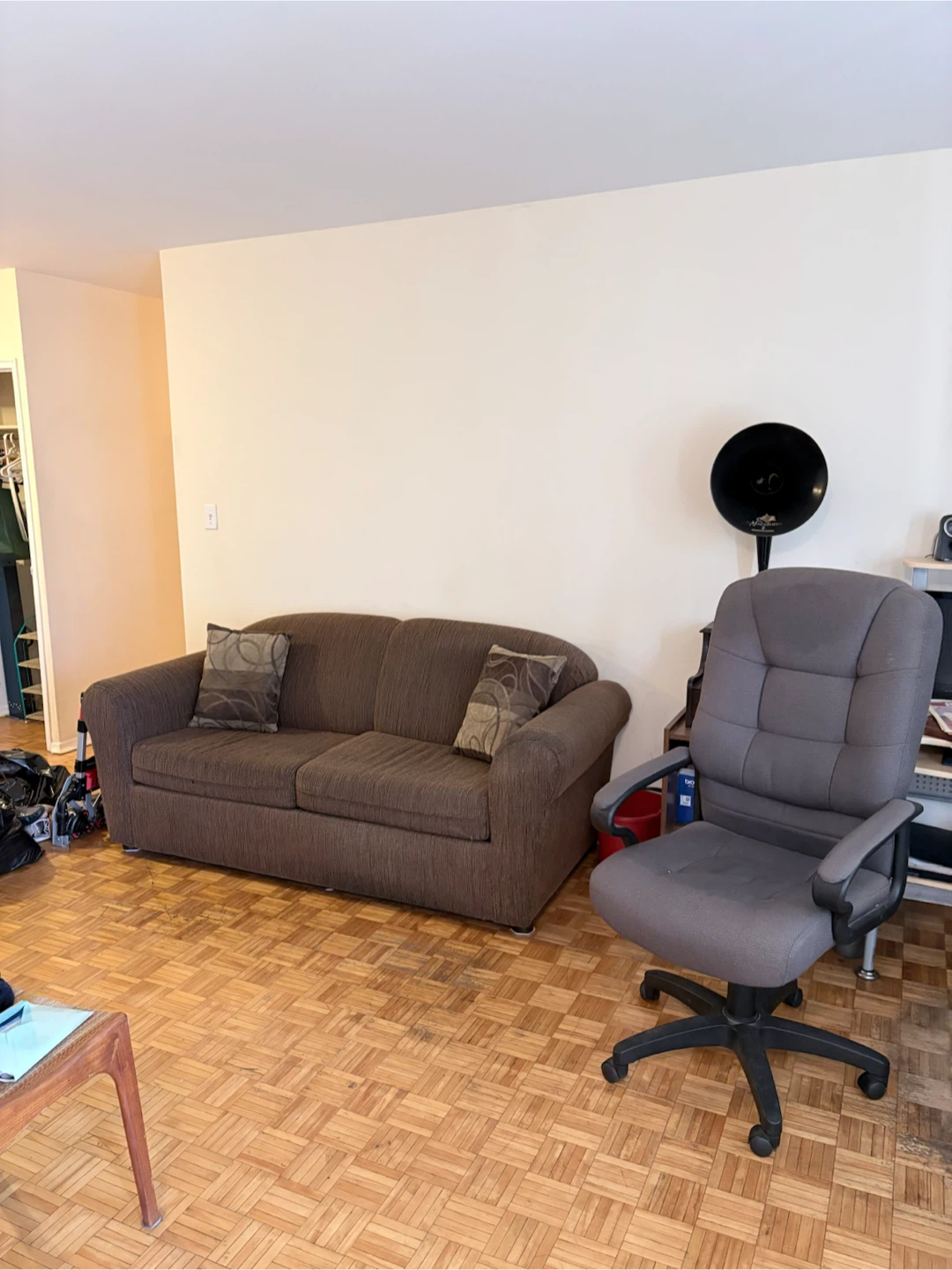 Brown  couch and grey desk chair