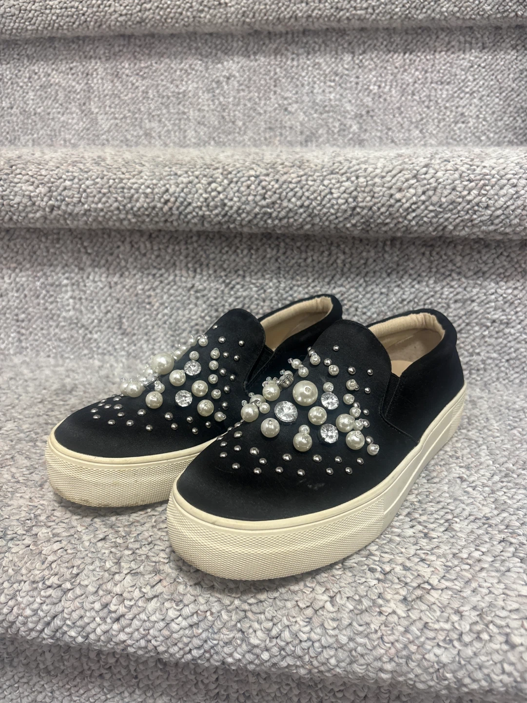 Black slip-on sneakers with pearl and rhinestone embellishments