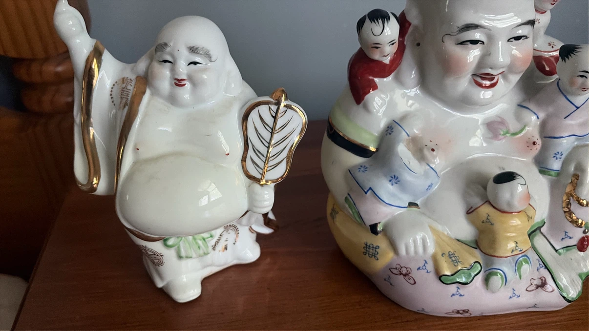 Two ceramic laughing Buddha statues with children