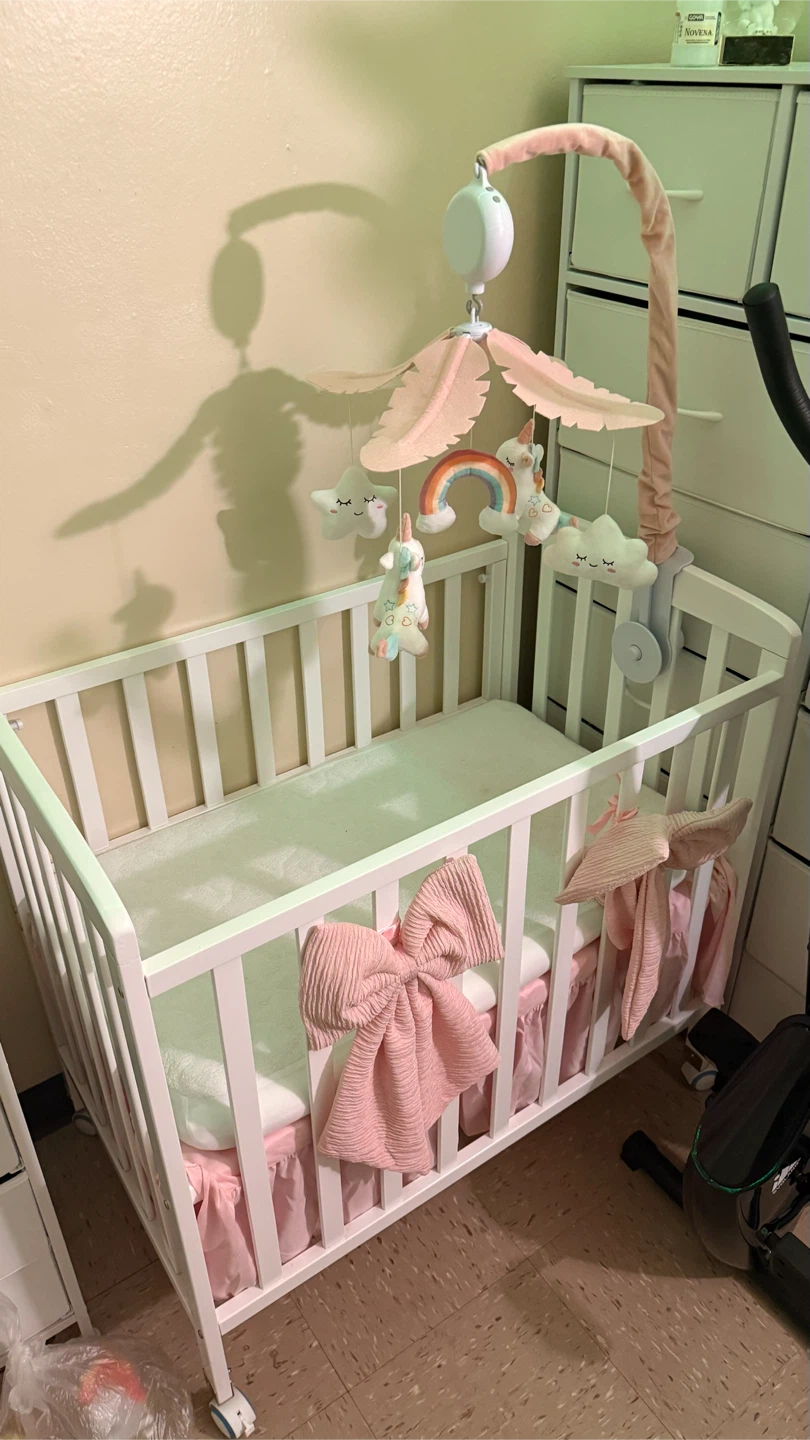 White Baby Crib with Pink Unicorn Mobile