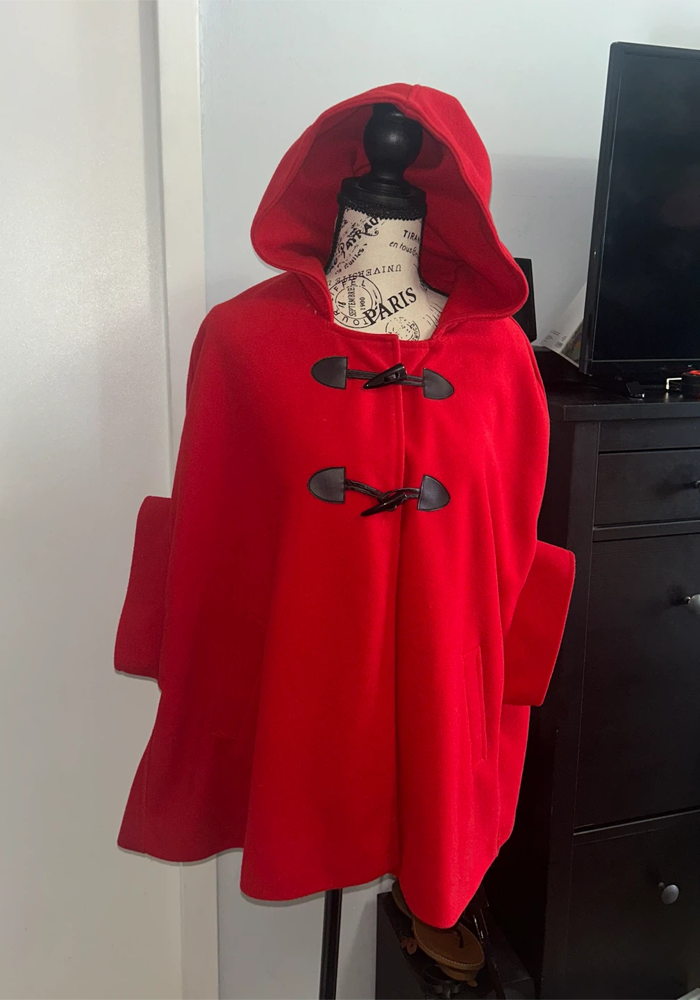 Red hooded cape with toggle closure and bow detail