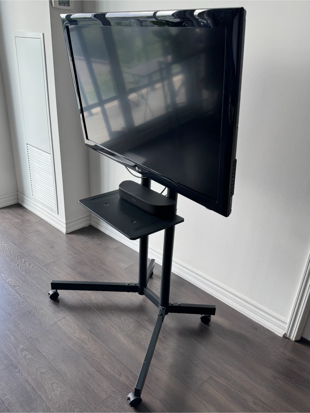 Roku LG TV on Rolling Stand with Soundbar and Remote