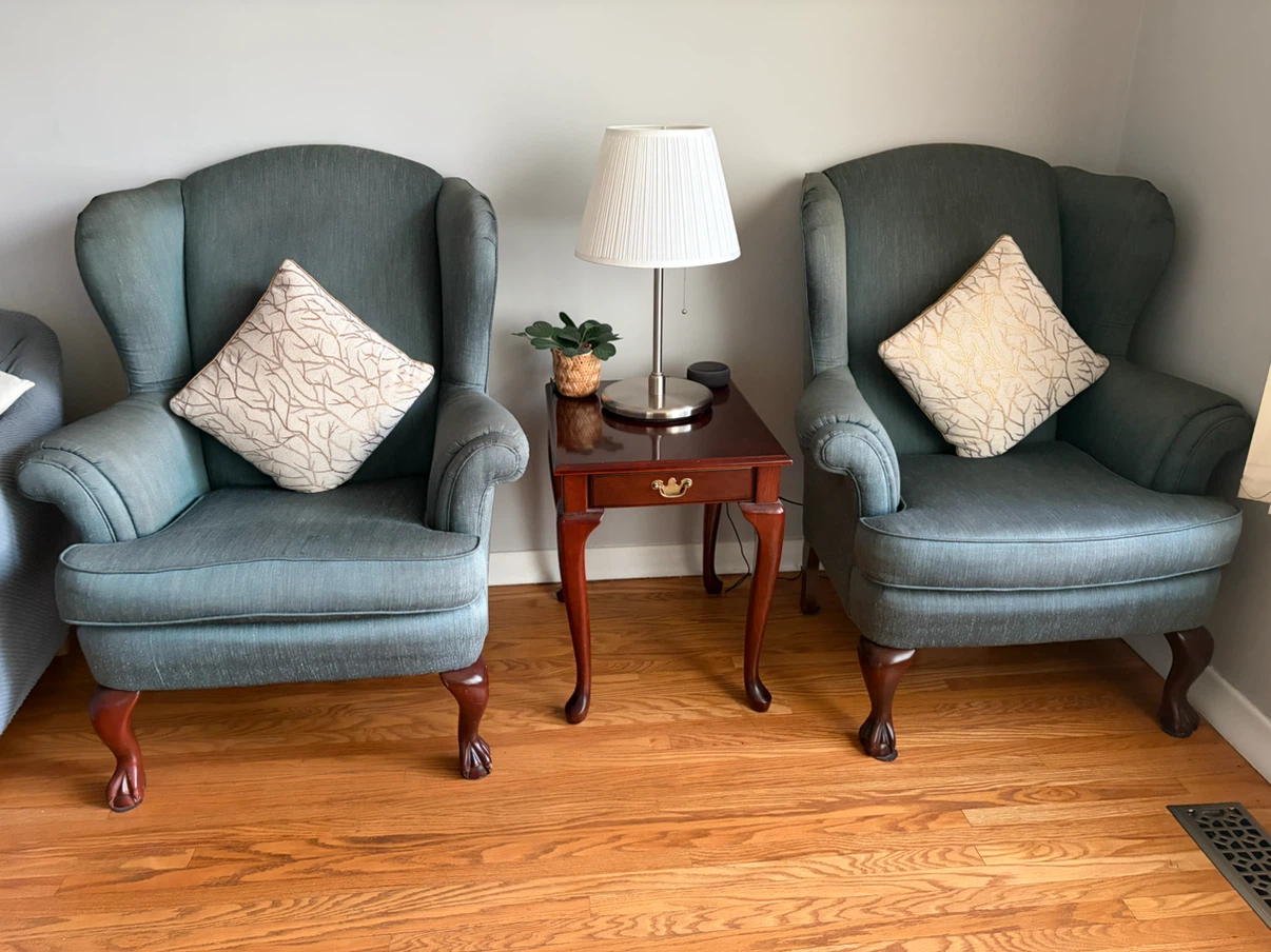 Two Teal Wingback Chairs with Decorative Pillows
