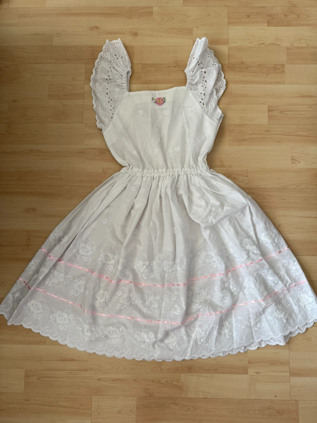 White eyelet sundress with pink ribbon accents