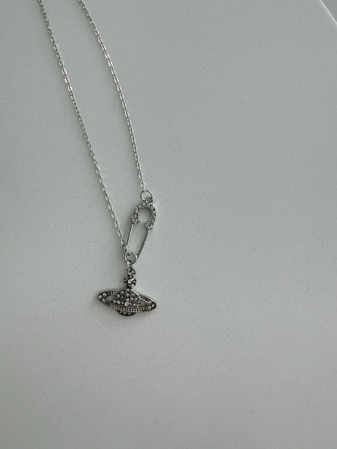 Silver planet pendant necklace with safety pin accent