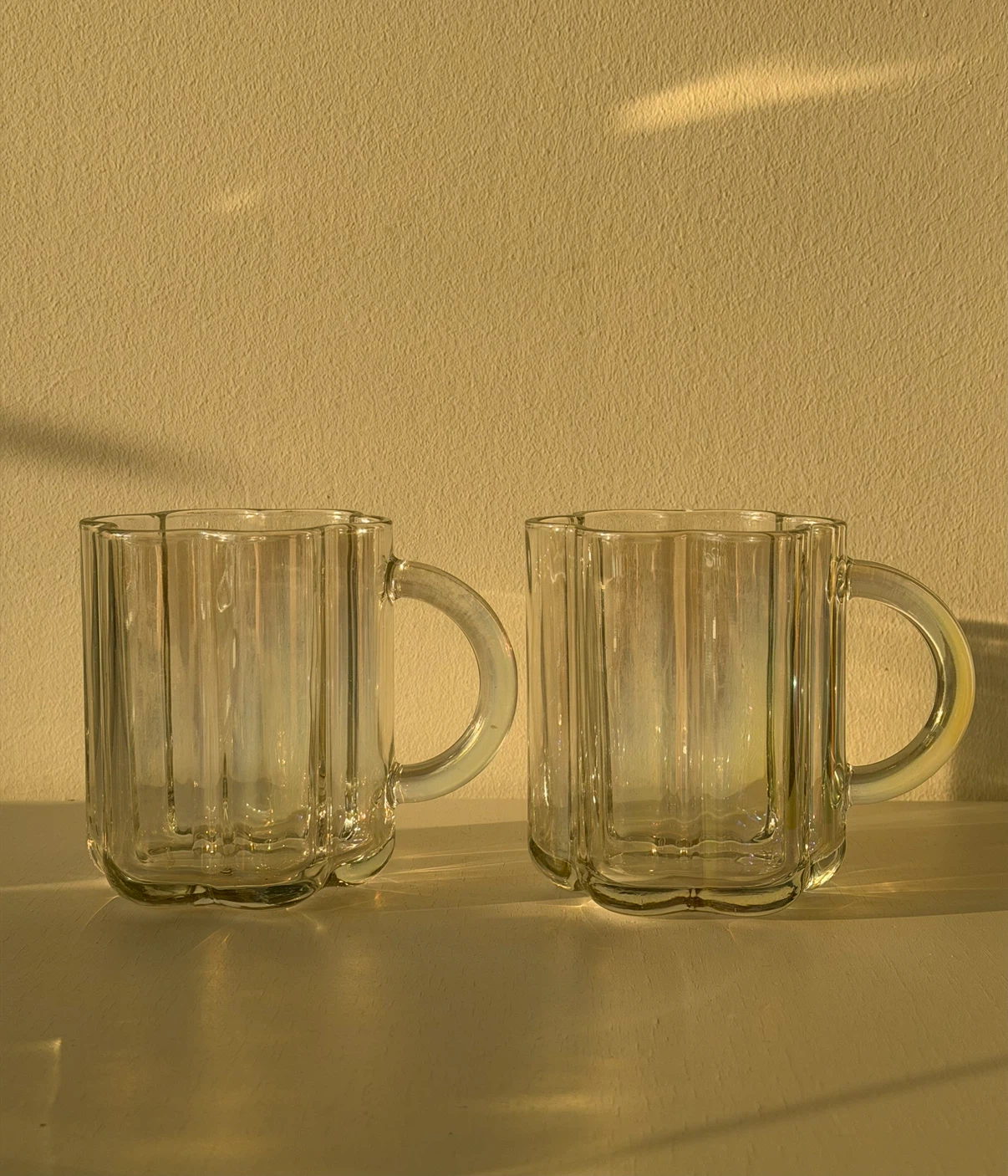 Iridescent glass mugs with scalloped silhouette