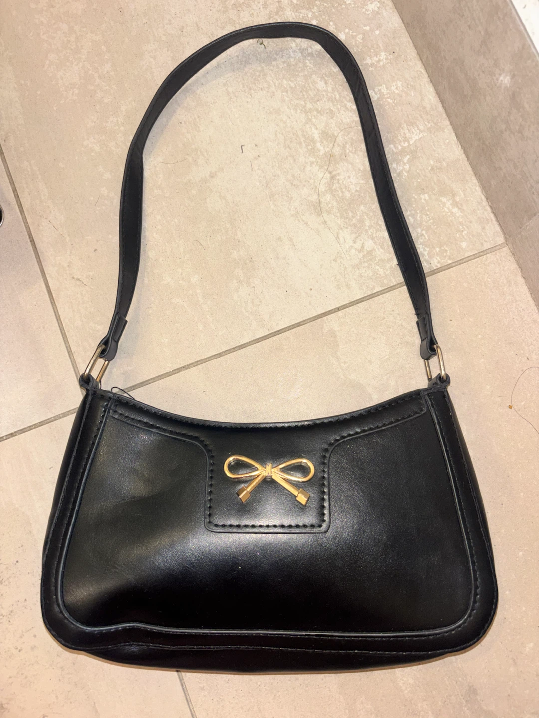Black shoulder bag with gold bow detail
