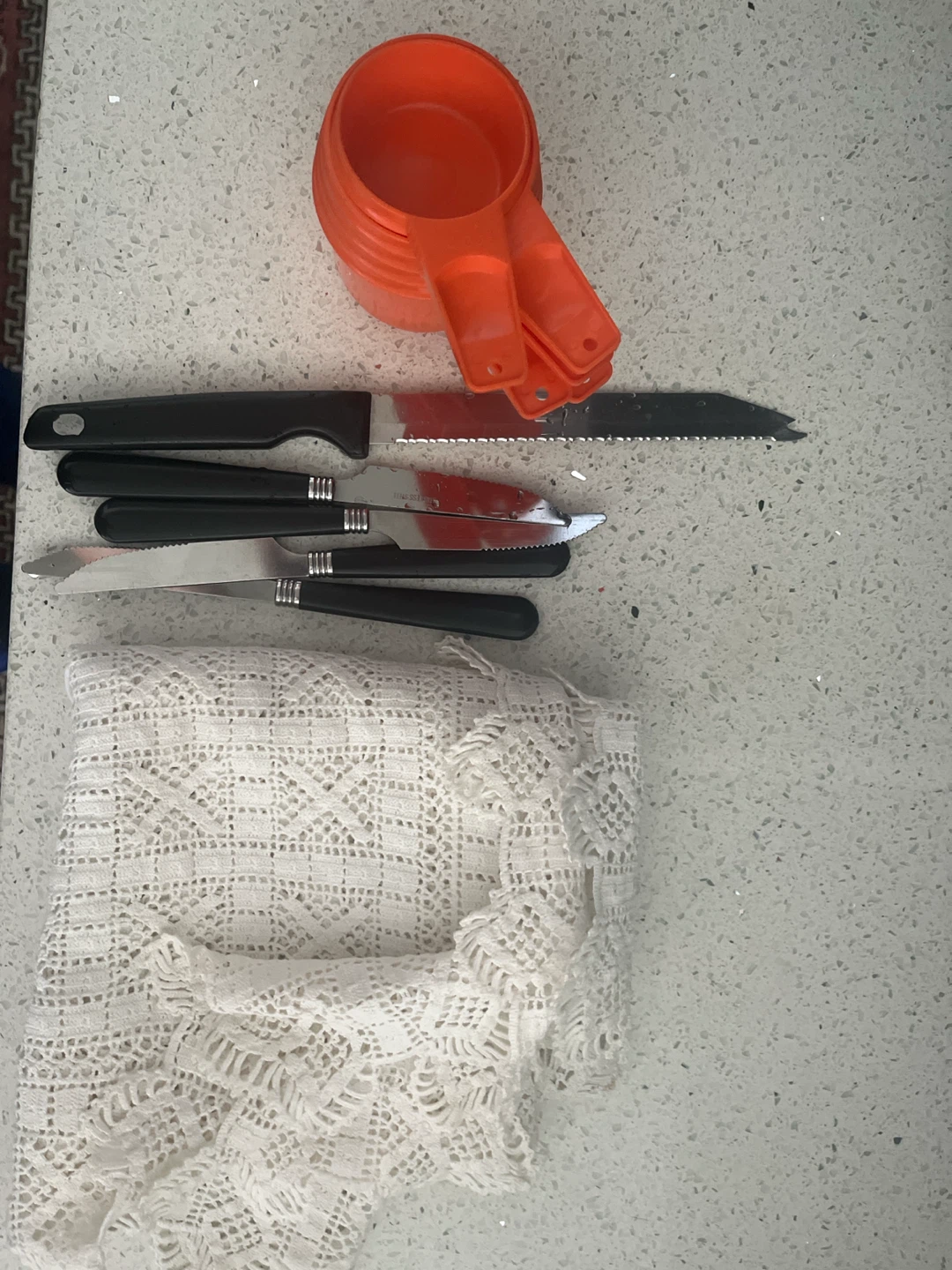 Set of Kitchen Knives and Measuring Cups with Lace Tablecloth