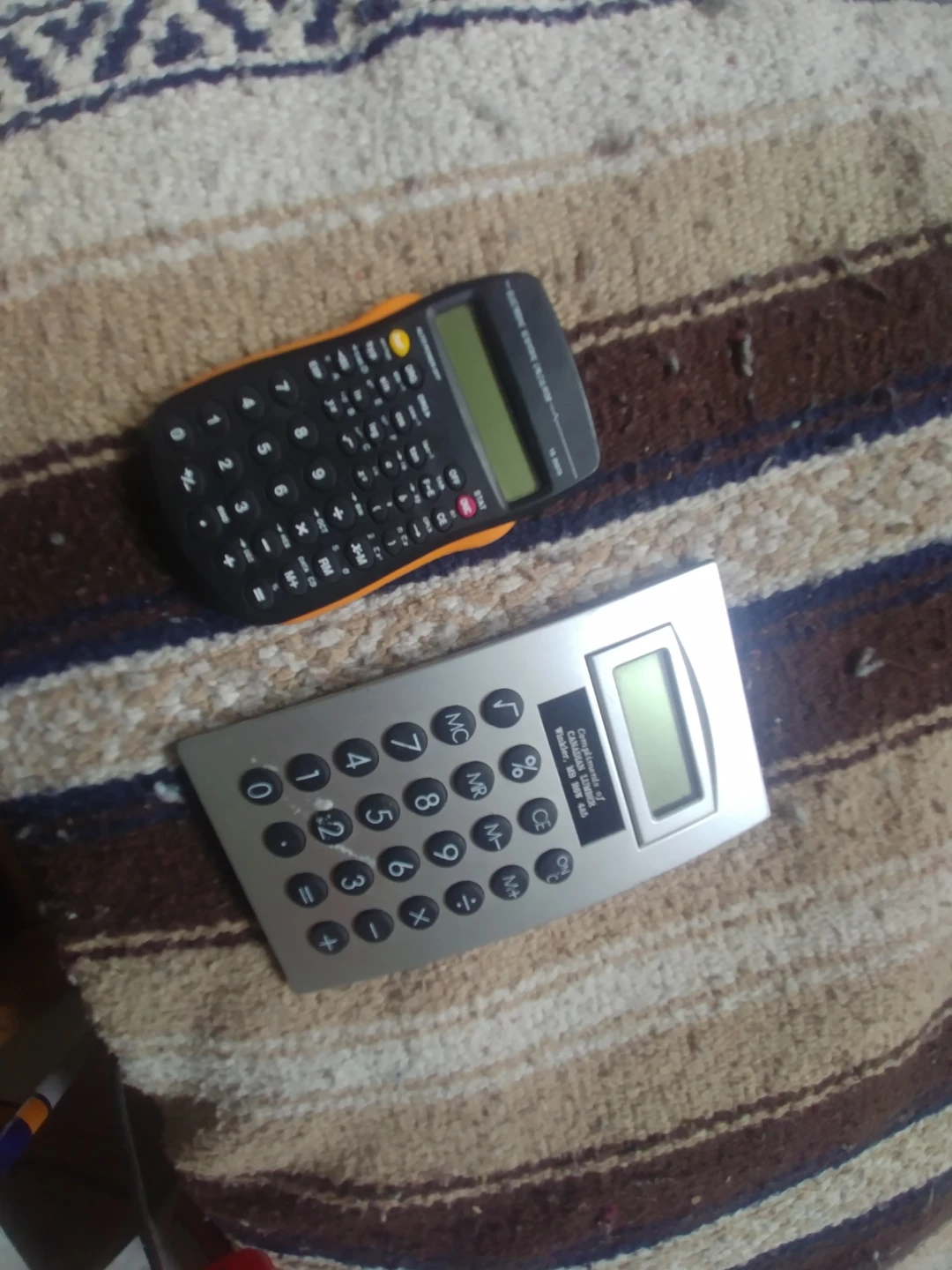 Two Calculators: Black Scientific & Silver Basic